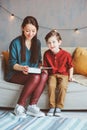 Happy mother reading book to child son at home