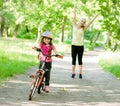 Happy mother rejoices that her daughter learned to ride a bike