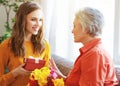 Happy mother`s day! adult daughter gives flowers and congratulates an elderly mother on holiday Royalty Free Stock Photo