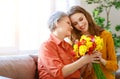 Happy mother`s day! adult daughter gives flowers and congratulates an elderly mother on holiday Royalty Free Stock Photo