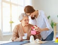 Happy mother`s day! adult daughter gives gift  and congratulates an elderly mother on holiday Royalty Free Stock Photo