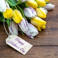 Happy Mother`s Day background panorama banner - bouquet of flowers with yellow, white / purple tulips and wooden label on a brown Royalty Free Stock Photo