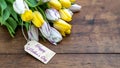 Happy Mother`s Day background panorama banner - bouquet of flowers with yellow, white / purple tulips and wooden label on a brown Royalty Free Stock Photo