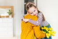 Happy Mother`s Day or Birthday Background. Adorable young girl surprising her mom, young cancer patient, with bouquet of tulips.