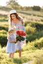 Happy mother`s day. Child daughter congratulates mom and gives her a bouquet of flowers outdoors. Mum and girl smiling and huggin Royalty Free Stock Photo