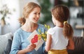 Happy mother`s day! Child daughter congratulates moms and gives her a postcard and yellow flowers tulip Royalty Free Stock Photo