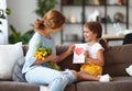 Happy mother`s day! Child daughter congratulates moms and gives her a postcard and yellow flowers tulip Royalty Free Stock Photo