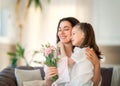 Daughter giving mother bouquet of flowers Royalty Free Stock Photo