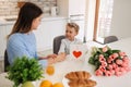 Happy mother\'s day! Child son congratulates moms and gives her a postcard and flowers Royalty Free Stock Photo