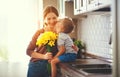 Happy mother`s day! child son gives flowersfor mother on holiday