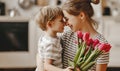 Happy mother`s day! child son gives flowers for mother on holiday