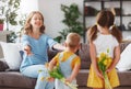 Happy mother`s day! Children congratulates moms and gives her a gift and flowers Royalty Free Stock Photo