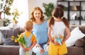 Happy mother`s day! Children congratulates moms and gives her a gift and flowers Royalty Free Stock Photo