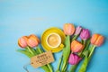 Happy Mother`s day concept with coffee cup and beautuful tulip flowers on woooden background. Top view from above