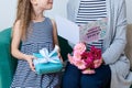 Happy Mother`s Day. Cute little girl giving mom greeting card, present and bouquet of pink gerbera daisies. Mother and daughter. Royalty Free Stock Photo