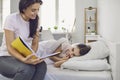 Happy Mother`s Day. Mother and daughter are reading a book while lying on the bed at home. Royalty Free Stock Photo