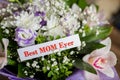 Happy Mother`s Day gift, and Best Mom Ever greeting card on table.Beautiful big bouquet with orchids flowers and Royalty Free Stock Photo