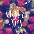 Happy mother`s day - Greeting card. Brush calligraphy greeting and hand drawn hearts on a blurred flowers background.