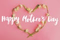 Happy mother`s day greeting card. Happy mother`s day text and floral heart flat lay on pink paper. Stylish floral greetings. Royalty Free Stock Photo