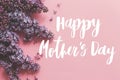 Happy mother`s day greeting card. Happy mother`s day text and lilac flowers on pink paper flat lay. Stylish floral greetings. Royalty Free Stock Photo