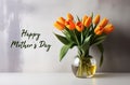Happy Mother\'s Day greeting card with with tulips yellow first spring flowers in a glass vase.