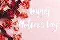 Happy mother`s day. Happy mothers day text and gift box with red flowers on pink background flat lay. Stylish floral greeting car Royalty Free Stock Photo