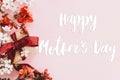 Happy mother`s day. Happy mothers day text and gift box with red and white flowers on pink background flat lay. Stylish floral Royalty Free Stock Photo
