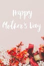 Happy mother`s day. Happy mothers day text and gift box with red and white flowers on pink background flat lay. Stylish floral Royalty Free Stock Photo