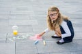 Happy Mother`s Day. A little girl draws for her mother a picture surprise of crayons on the asphalt. Royalty Free Stock Photo