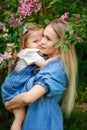 Happy mother`s day. Little girl hugs her mother in the spring cherry garden. Portrait of happy mother and daughter among pink Royalty Free Stock Photo