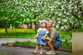 Happy mother`s day. Little girl hugs her mother in the spring cherry garden. Portrait of happy mother and daughter among white Royalty Free Stock Photo