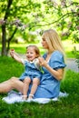 Happy mother`s day. Little girl hugs her mother in the spring cherry garden. Portrait of happy mother and daughter among pink Royalty Free Stock Photo