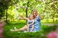 Happy mother`s day. Little girl hugs her mother in the spring cherry garden. Portrait of happy mother and daughter among pink Royalty Free Stock Photo
