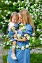 Happy mother`s day. Little girl hugs her mother in the spring cherry garden. Portrait of happy mother and daughter among white Royalty Free Stock Photo