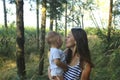 Happy mother`s day Mom and son in a pine forest. Mom and son are smiling and hugging. Family holidays and socializing