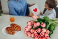 Happy Mother`s day! Small son hugging her mom on kitchen. Happy family concept