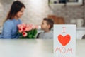 Happy Mother`s day! Small son hugging her mom on kitchen. Happy family concept