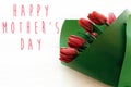 Happy Mother`s Day text and beautiful red tulips on white wooden background flat lay. Happy mother day greeting card with spring