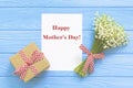 Happy Mother`s day text on blue rustic wooden background. greeting card and gift box concept spring flowers flat lay Royalty Free Stock Photo