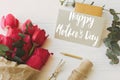 Happy mother`s day. Happy mother`s day text on card and red tulips, gift, pencil, scissors and twine on rustic white wood. Styli Royalty Free Stock Photo
