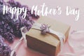 Happy Mother`s day text and lilac flowers, gift box on pink background. Stylish purple lilac flowers bouquet, craft present box Royalty Free Stock Photo