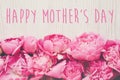 Happy mother`s day text on pink peonies bouquet on rustic white