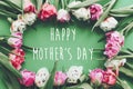 Happy Mother`s Day text sign on beautiful double peony tulips frame flat lay on green paper. Stylish floral greeting card. Thank