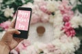 Happy Mother`s Day text sign on screen phone in hand at stylish pink and white peonies on pastel pink paper, flat lay. Stylish Royalty Free Stock Photo