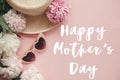 Happy Mother`s Day text sign at stylish girly pink retro sunglasses, white and pink peonies, straw hat on pastel pink paper.