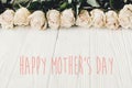 Happy Mother`s Day text sign at white roses on wooden background. Floral greeting card. Stylish border of white flowers. Mothers Royalty Free Stock Photo