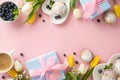 Top view flat lay of plates with yummy cupcakes, blue presents, blueberries, cup of coffee, tulips pink background Royalty Free Stock Photo