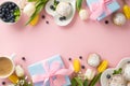 Top view flat lay of plates with yummy cupcakes, blue presents, blueberries, cup of coffee, tulips pink background