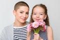Happy Mother`s Day, Women`s day or Birthday background. Cute little girl giving mom, cancer survivor, bouquet of pink daisies.