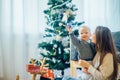 Happy mother showing Christmas ball to baby near Christmas tree Royalty Free Stock Photo